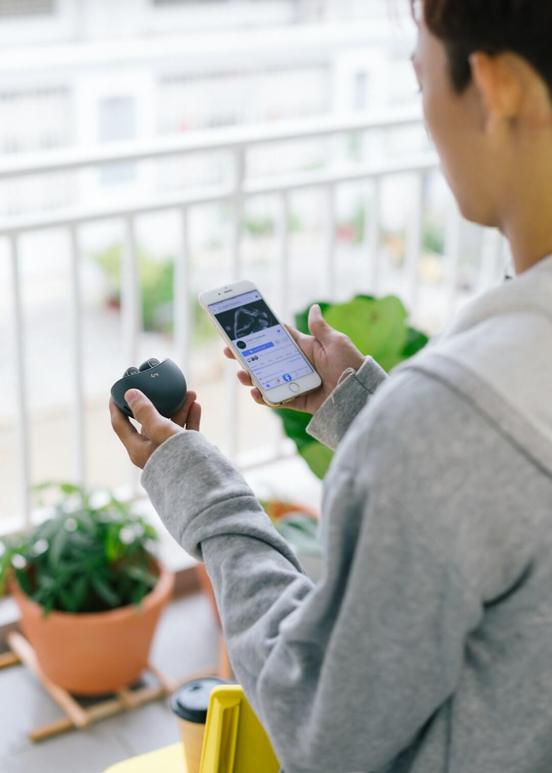 Person holding a smartphone with a list on screen.