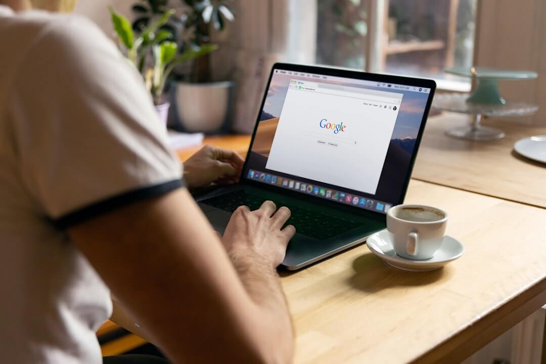 a man sitting at a table using a laptop computer
