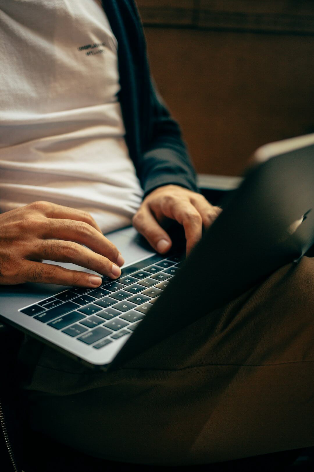man holding mouse and iPhone while using Macbook Pro