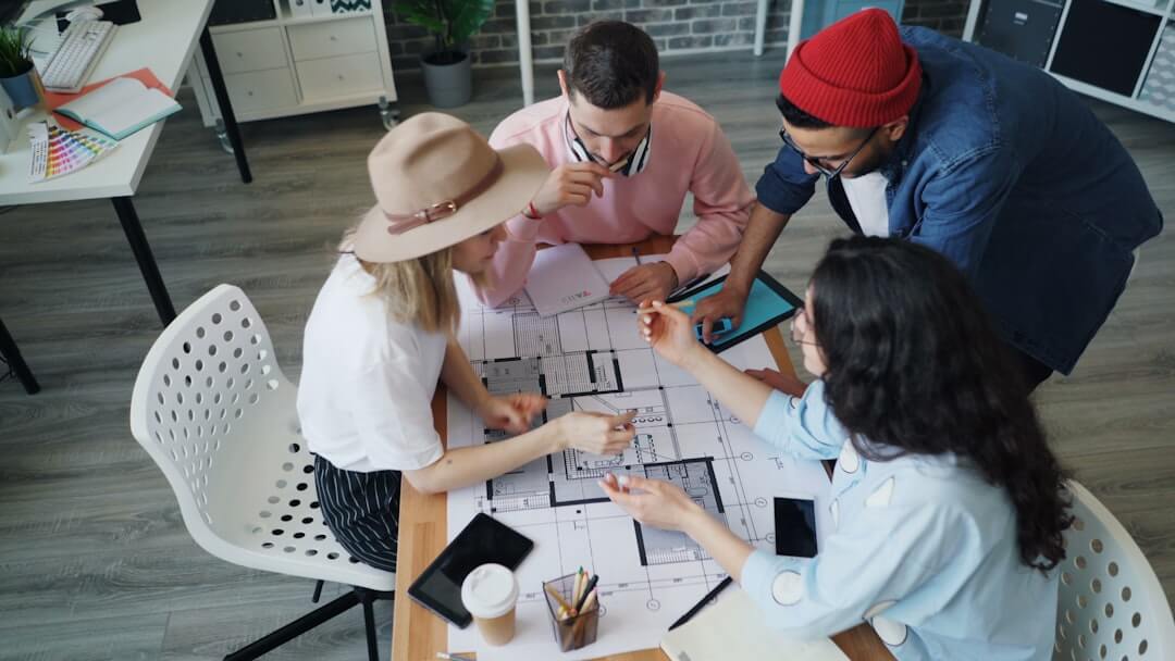 a group of people sitting around a table working on a project