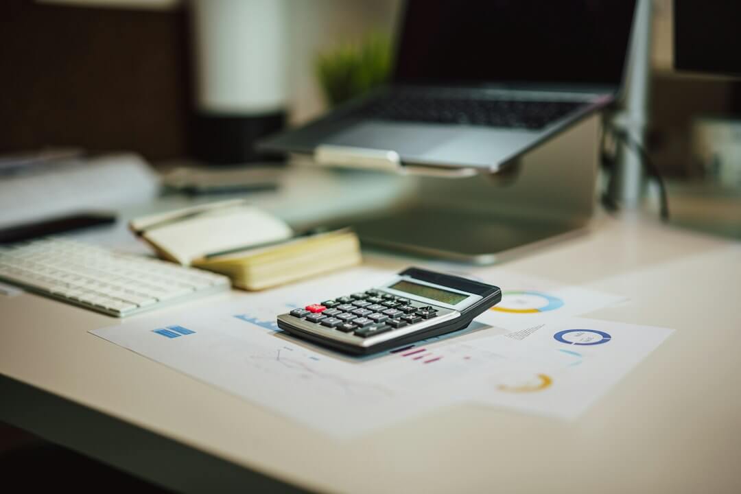 black and silver calculator beside black pen