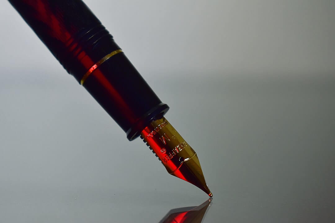 a red pen sitting on top of a book