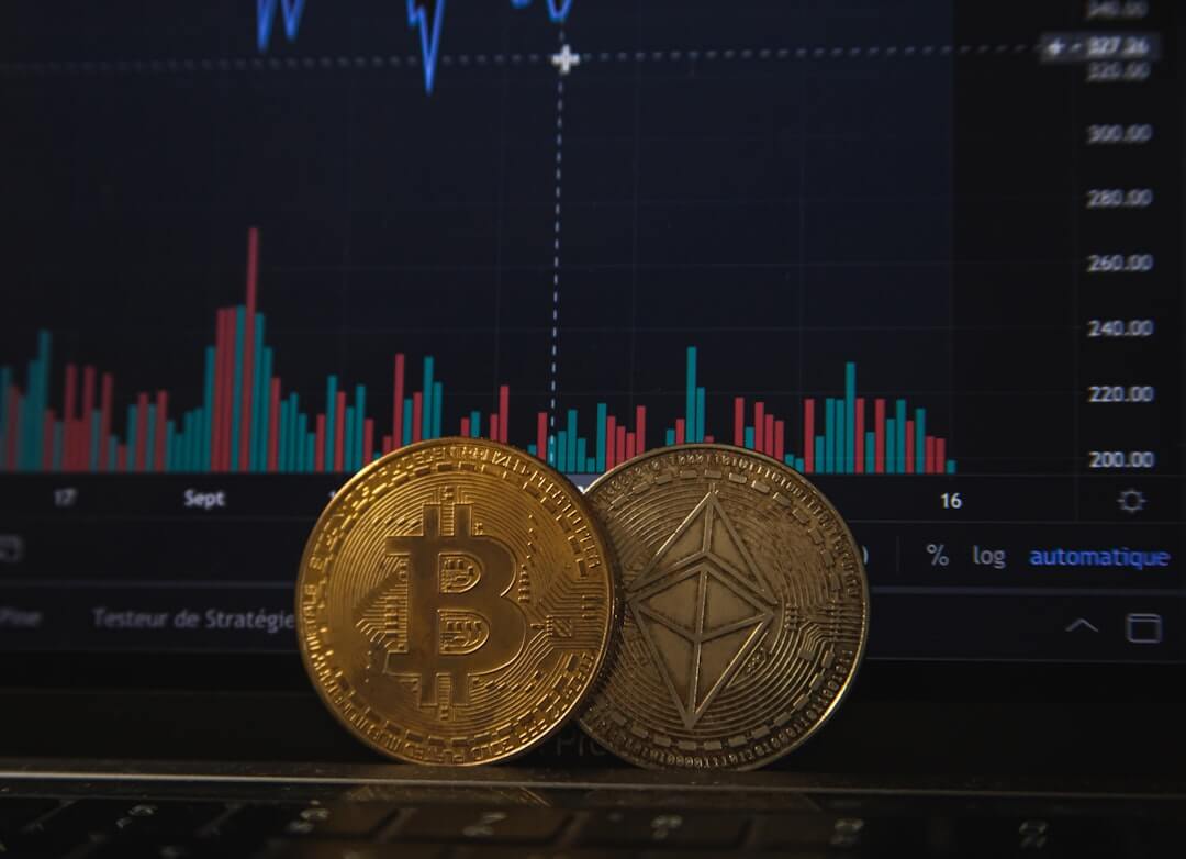 Hand holding ethereum with crypto graphs in background.