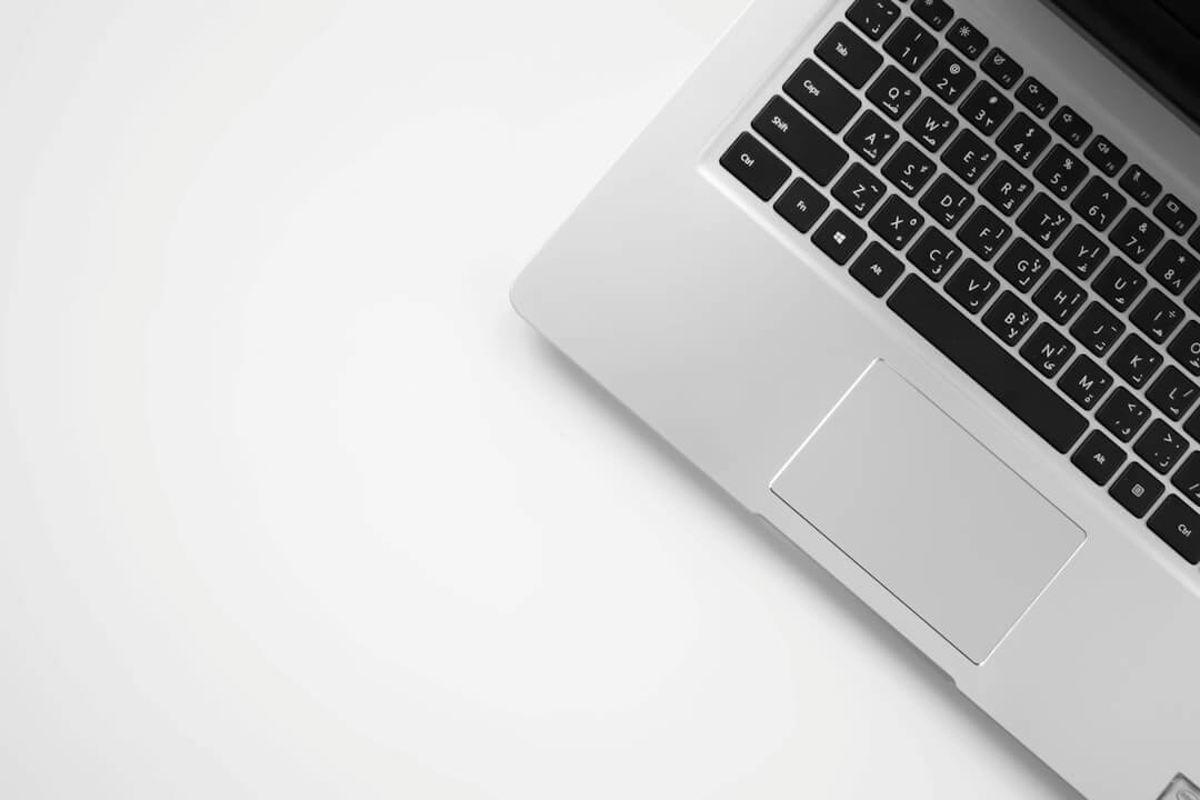 silver MacBook beside space gray iPhone 6 and clear drinking glass on brown wooden top