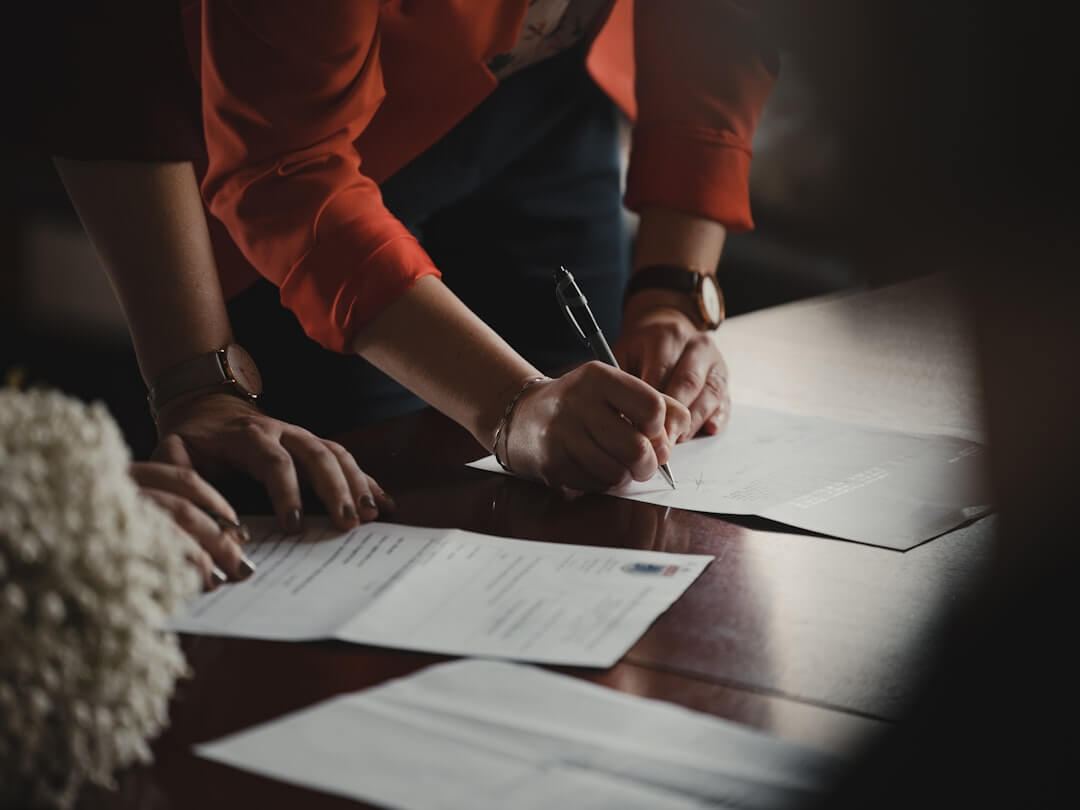 a woman sitting at a table reading a paper