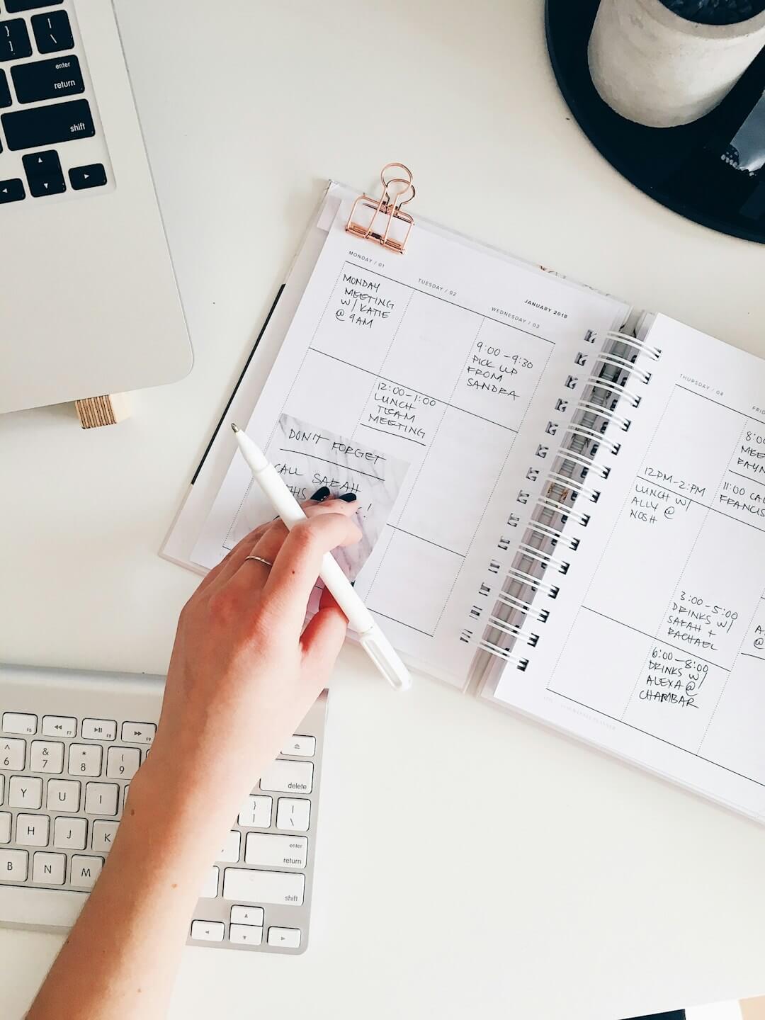 A black spiral notebook with the word PLAN written on a yellow background