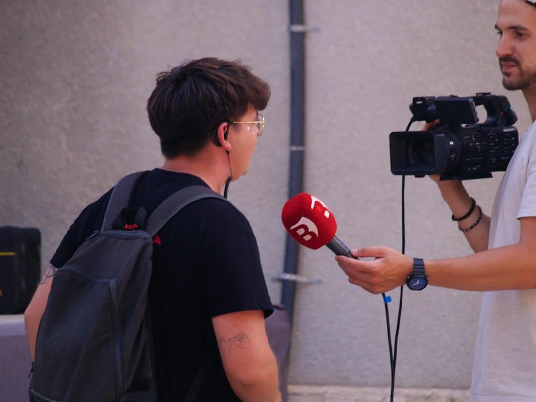 A man sitting in a chair in front of a microphone