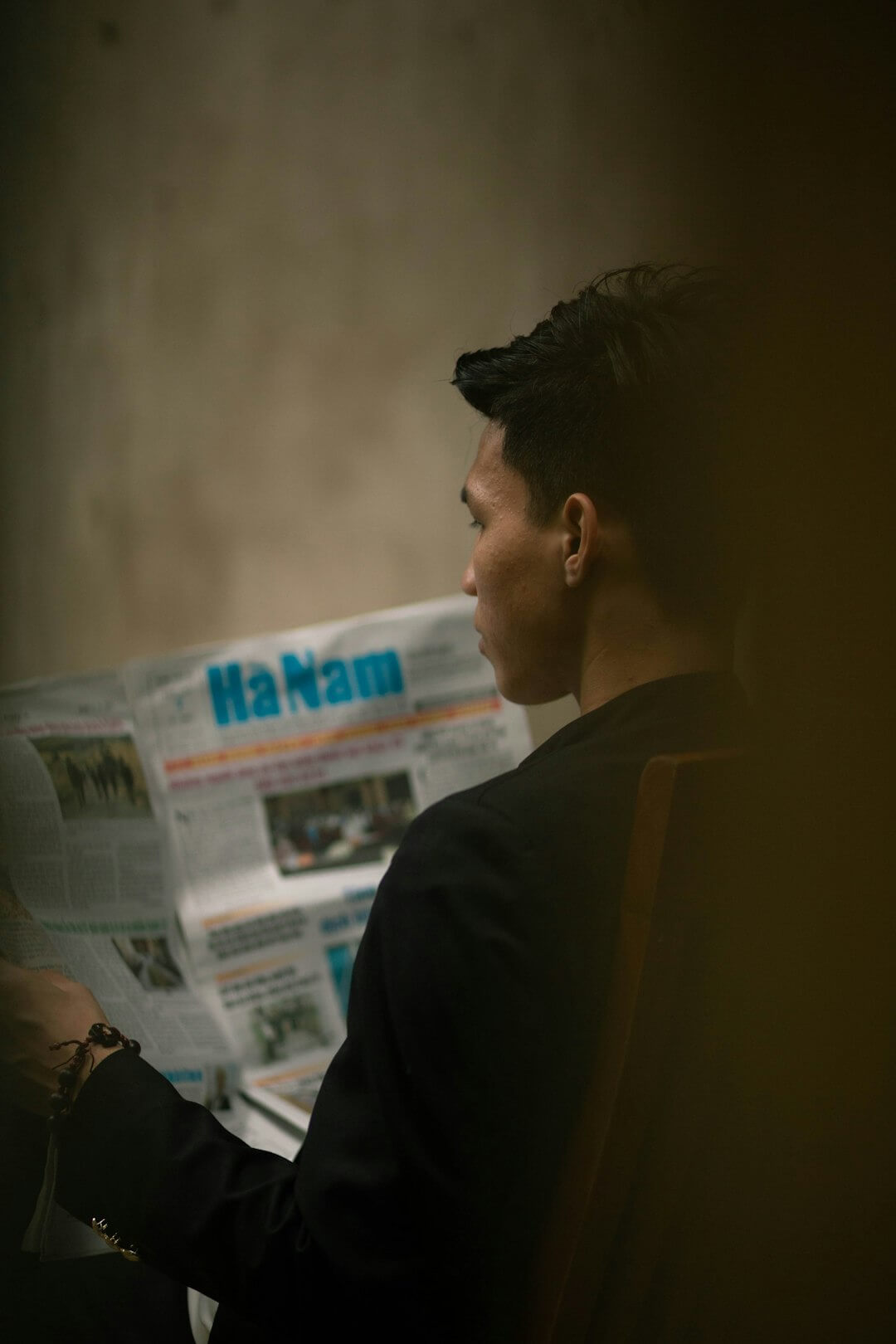 a man sitting at a desk reading a newspaper