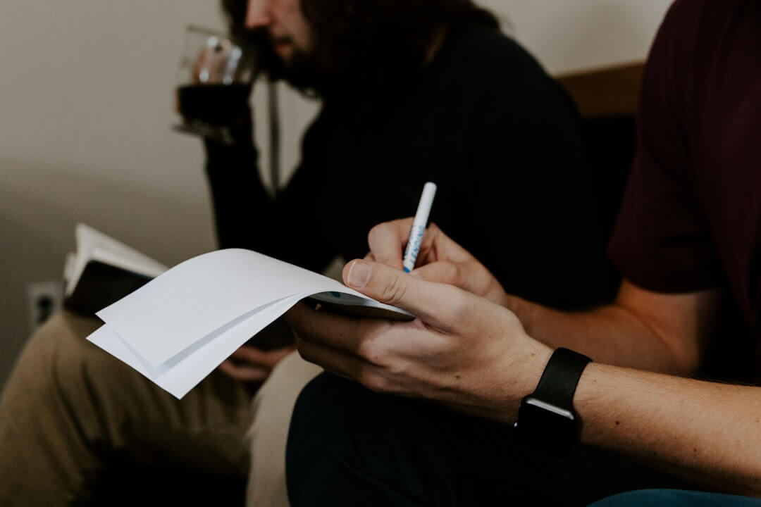 a man sitting at a table holding a piece of paper