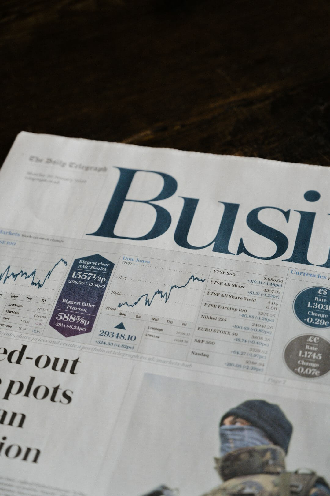 person wearing suit reading business newspaper