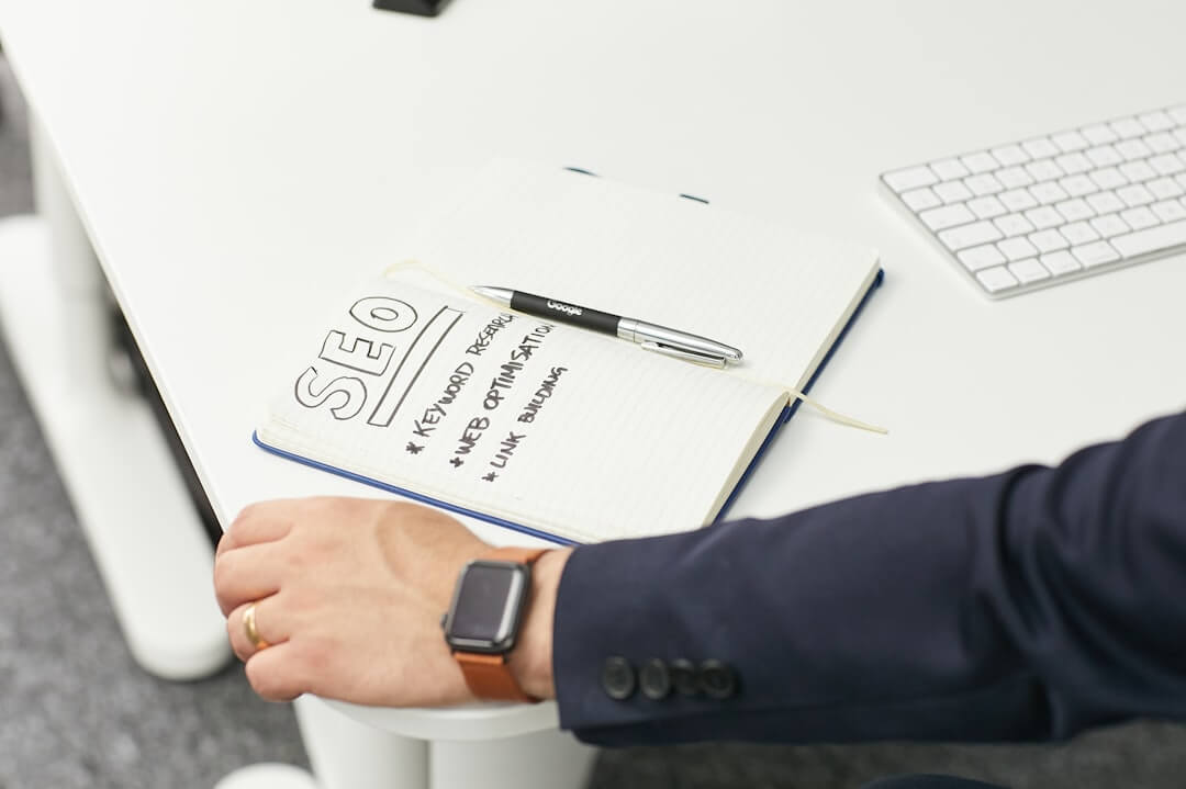 a cup of coffee and a notepad on a desk