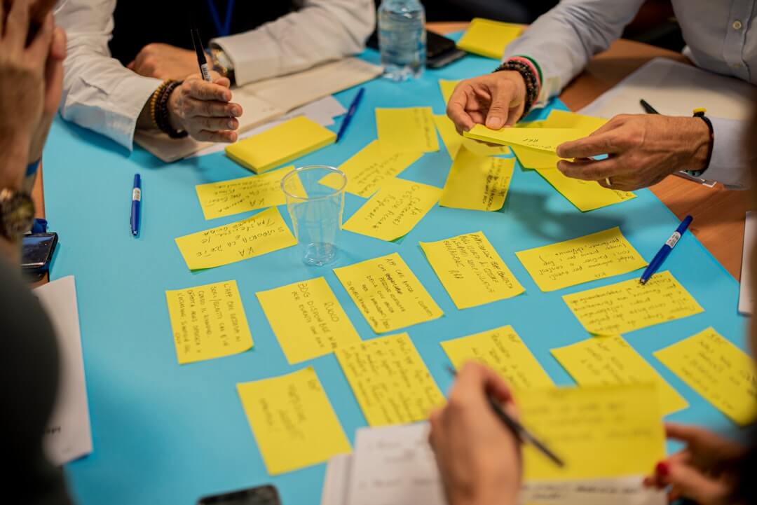 a group of people sitting around a table with papers