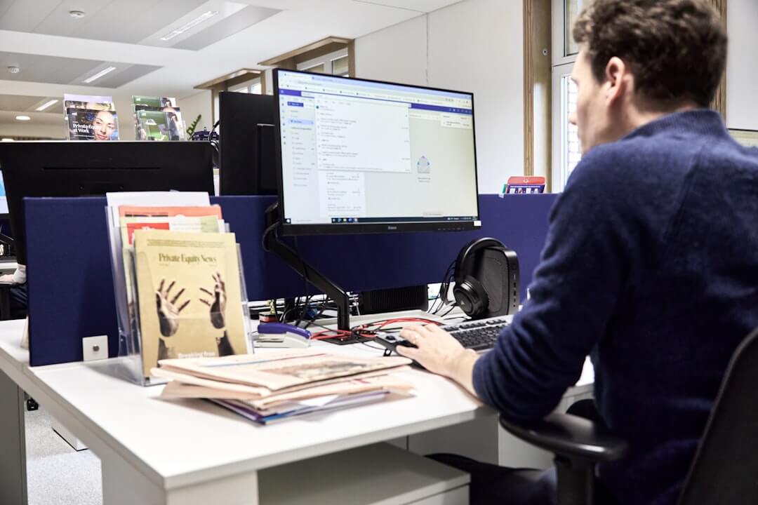 Young woman focused on computer screen in office.