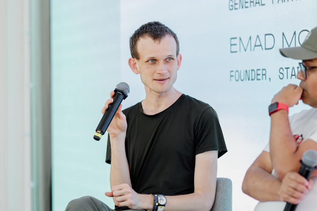 a man wearing headphones sitting in front of a microphone