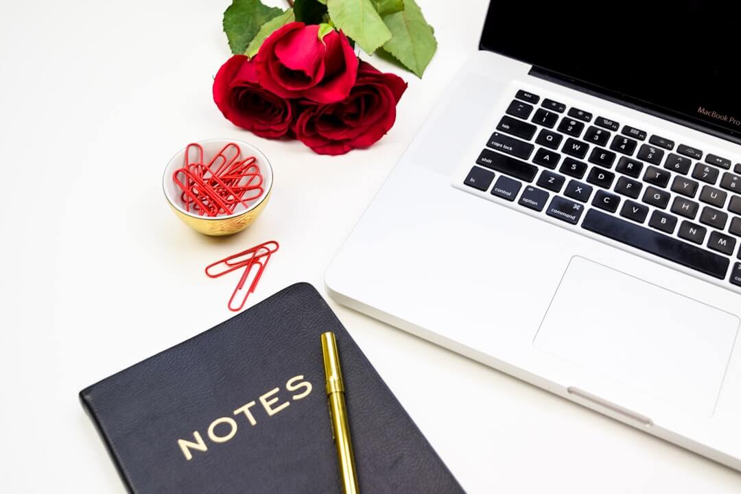 woman in white long sleeve shirt writing on white paper