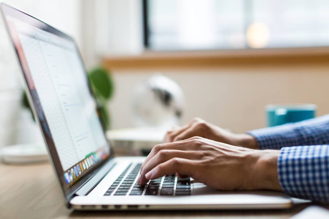 person seated at the table using laptop