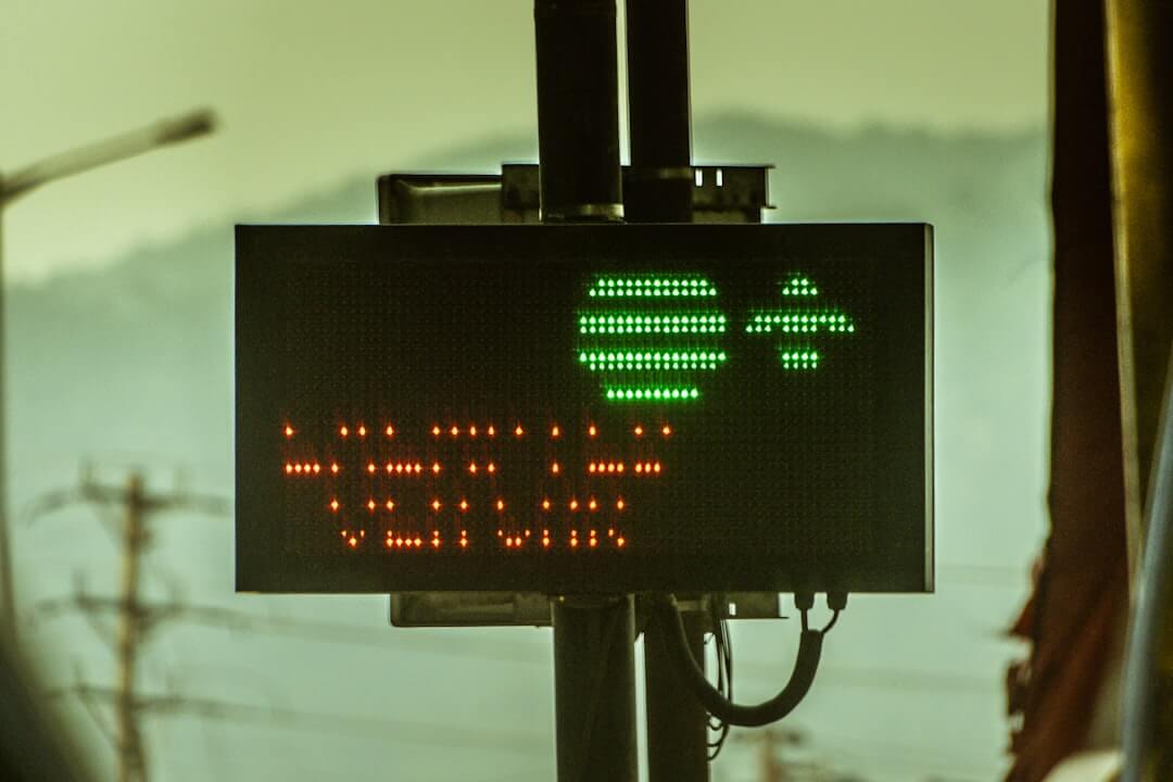 a street sign with a yellow light on top of it