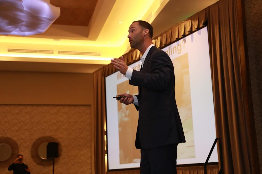 A man presents a graph to colleagues in a meeting.