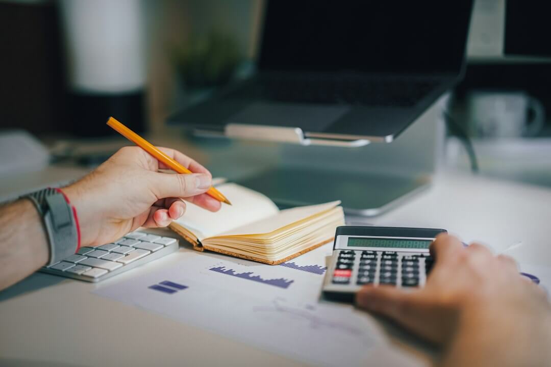 a calculator sitting on top of a table next to a laptop