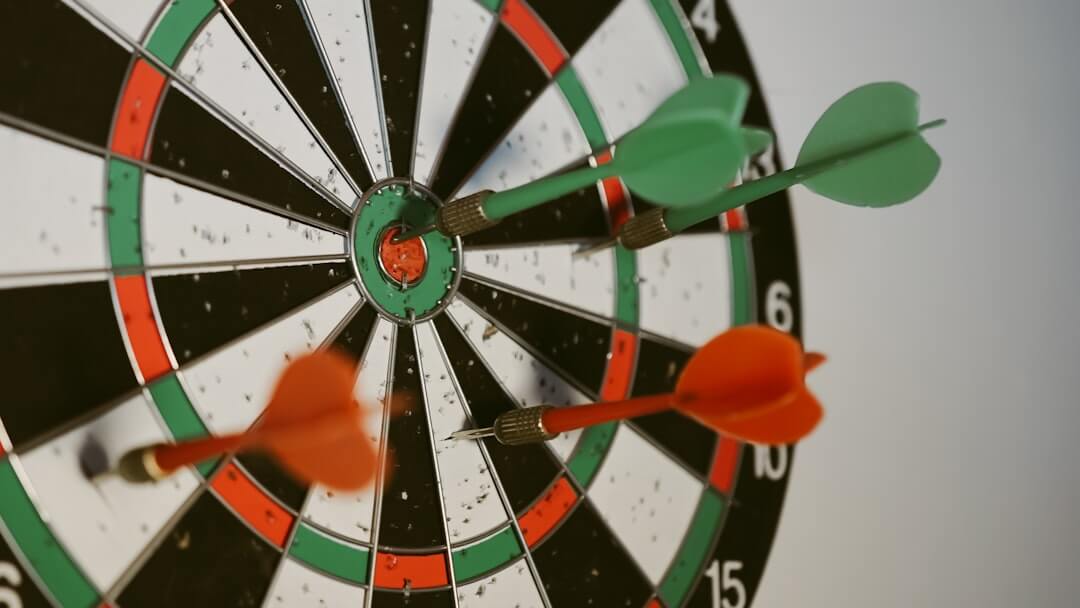 a dart hitting in the center of a dartboard on a wooden wall