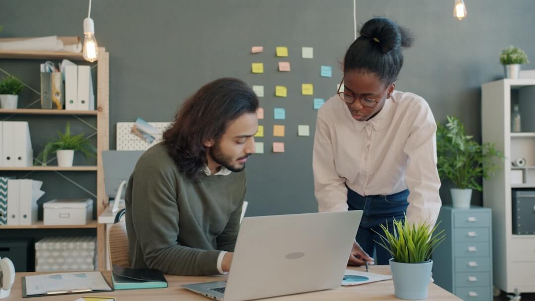 Two colleagues collaborating on a project at a desk.