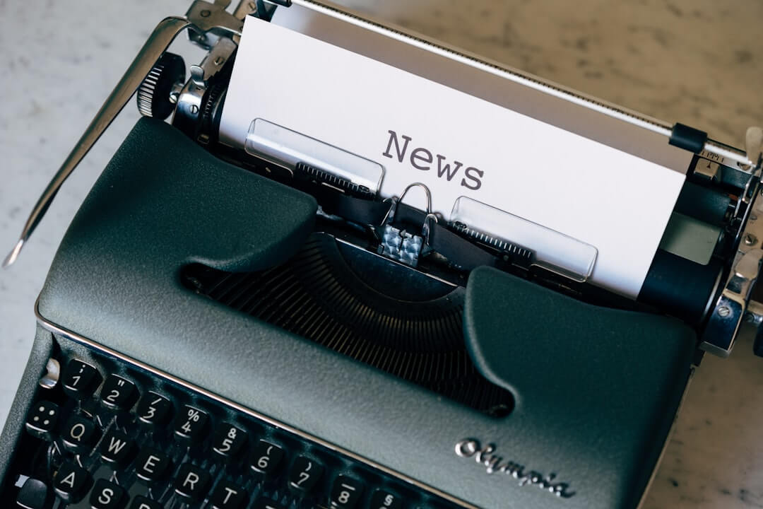 a close up of a typewriter with news paper on it