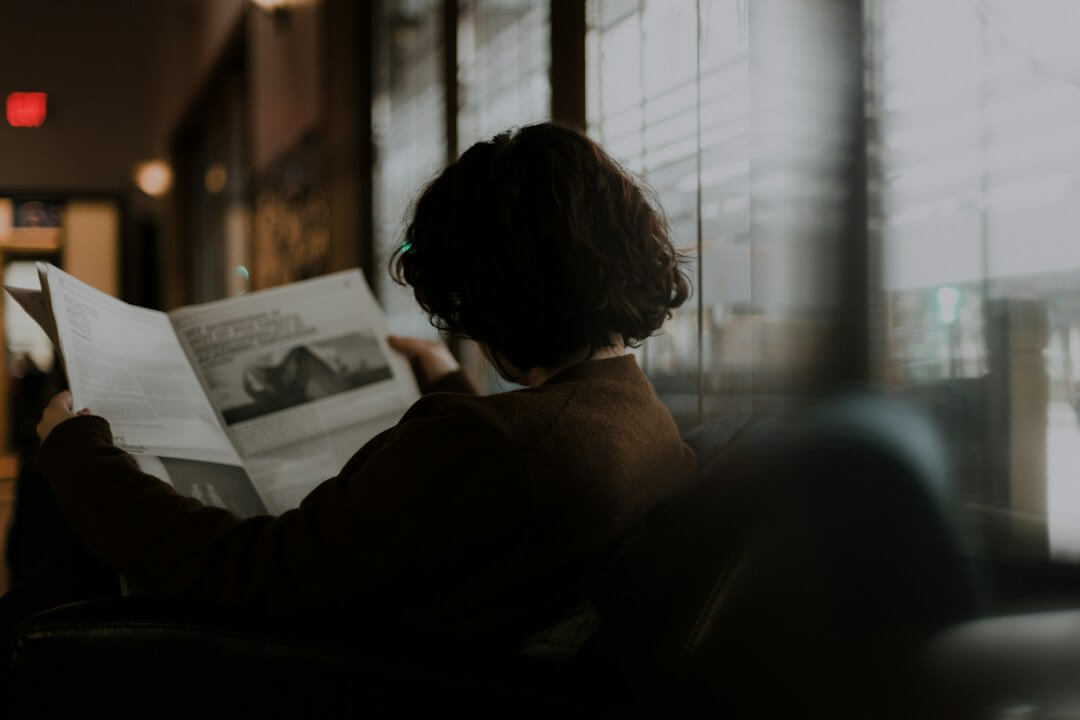 A man sitting on a bench reading a newspaper