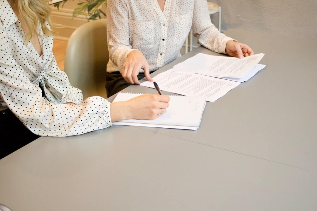 Woman in suit reviews document with man.