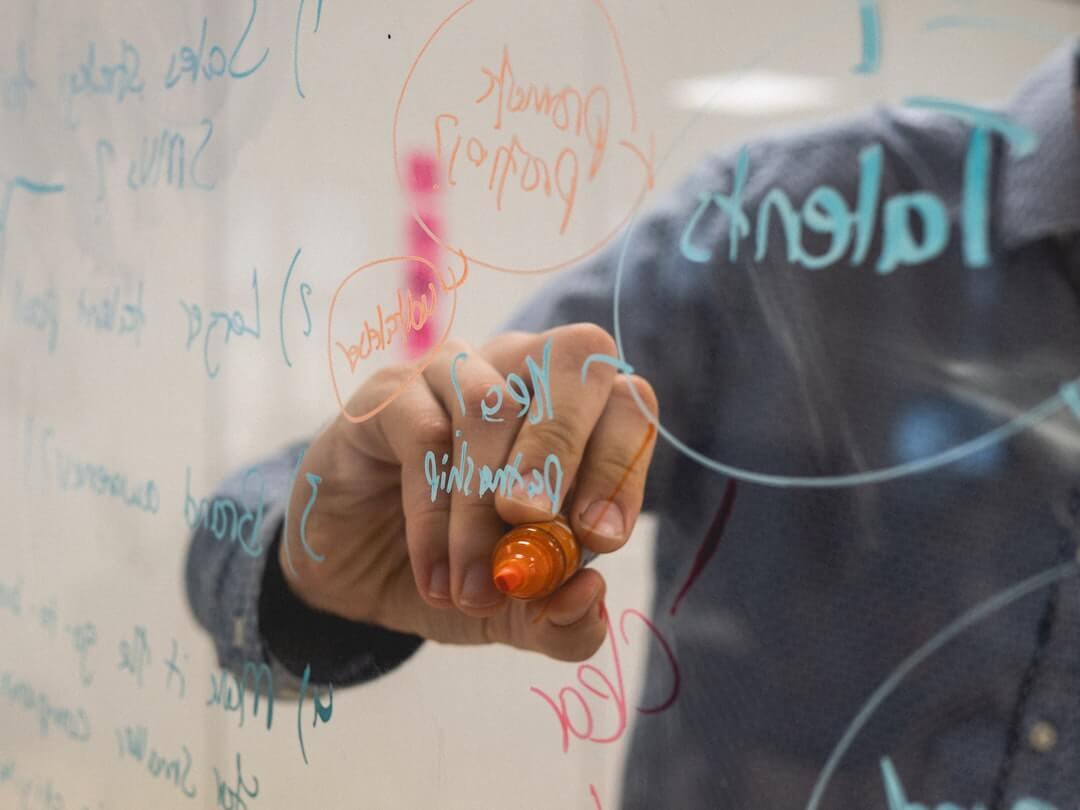 a man standing in front of a white board