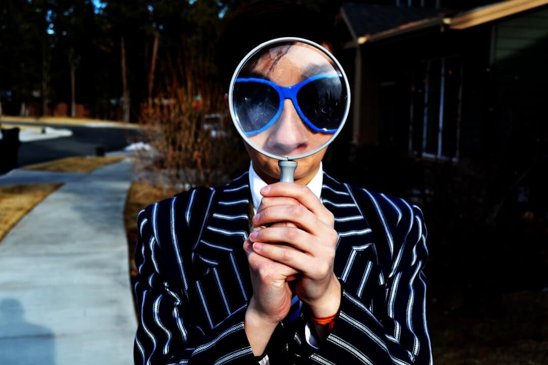 Magnifying glass sits near a laptop on a table.