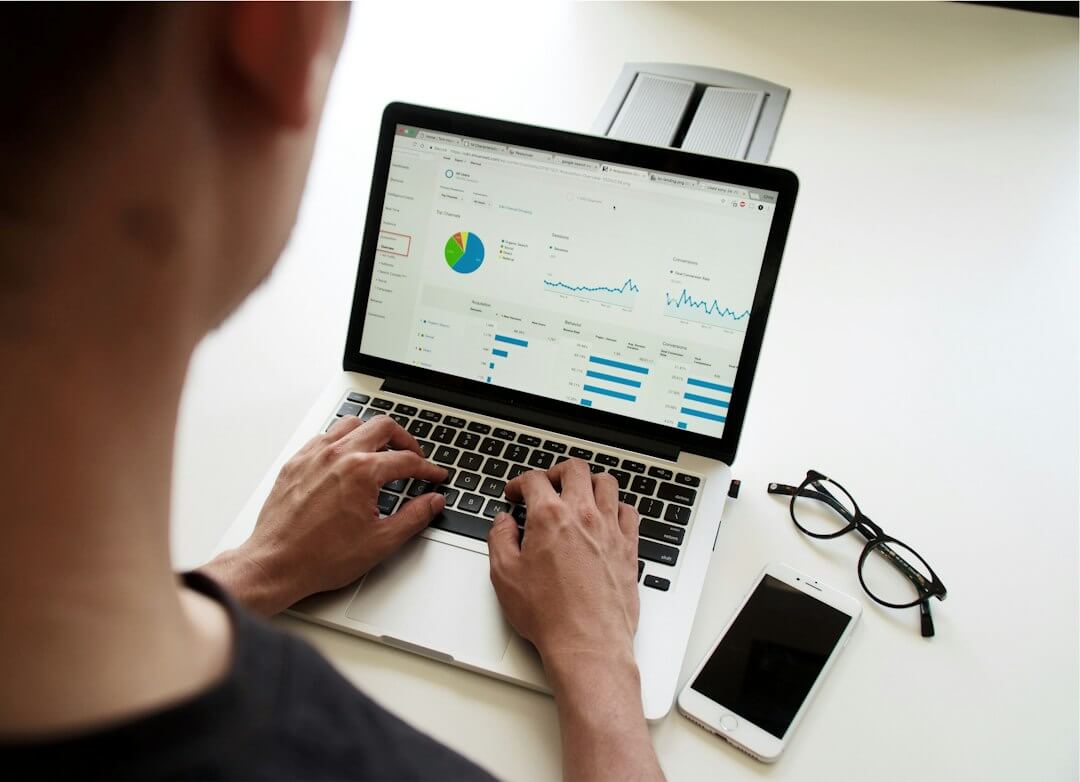 person using macbook pro on black table