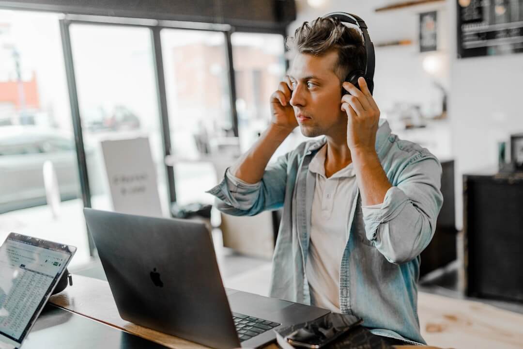 two black headphones on brown wooden table