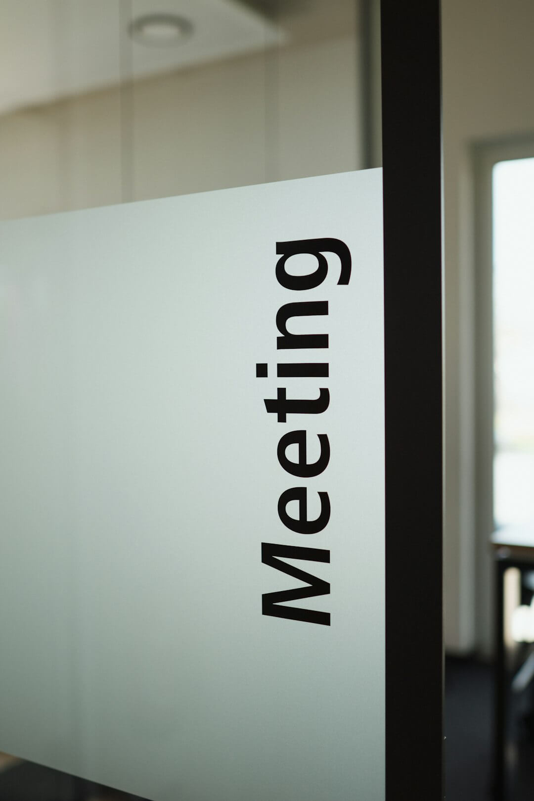 a sign on a glass door that says meeting room