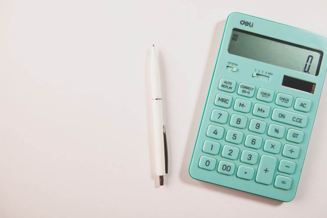 A black pen, phone case, and keyboard on a desk