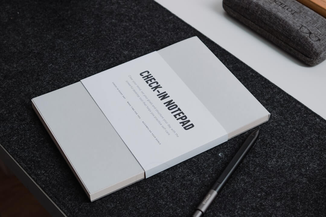 black spring notebook on brown wooden table