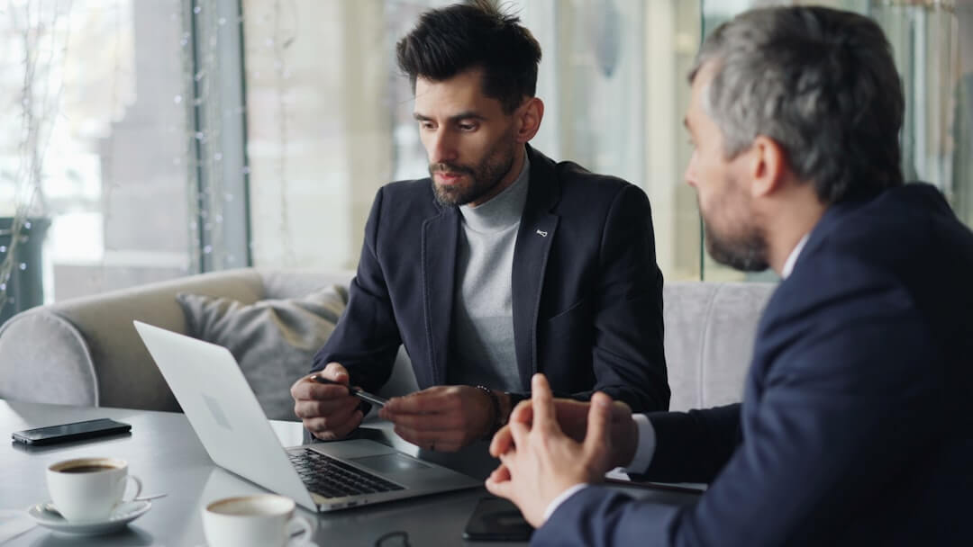 two men sitting at a table having a conversation